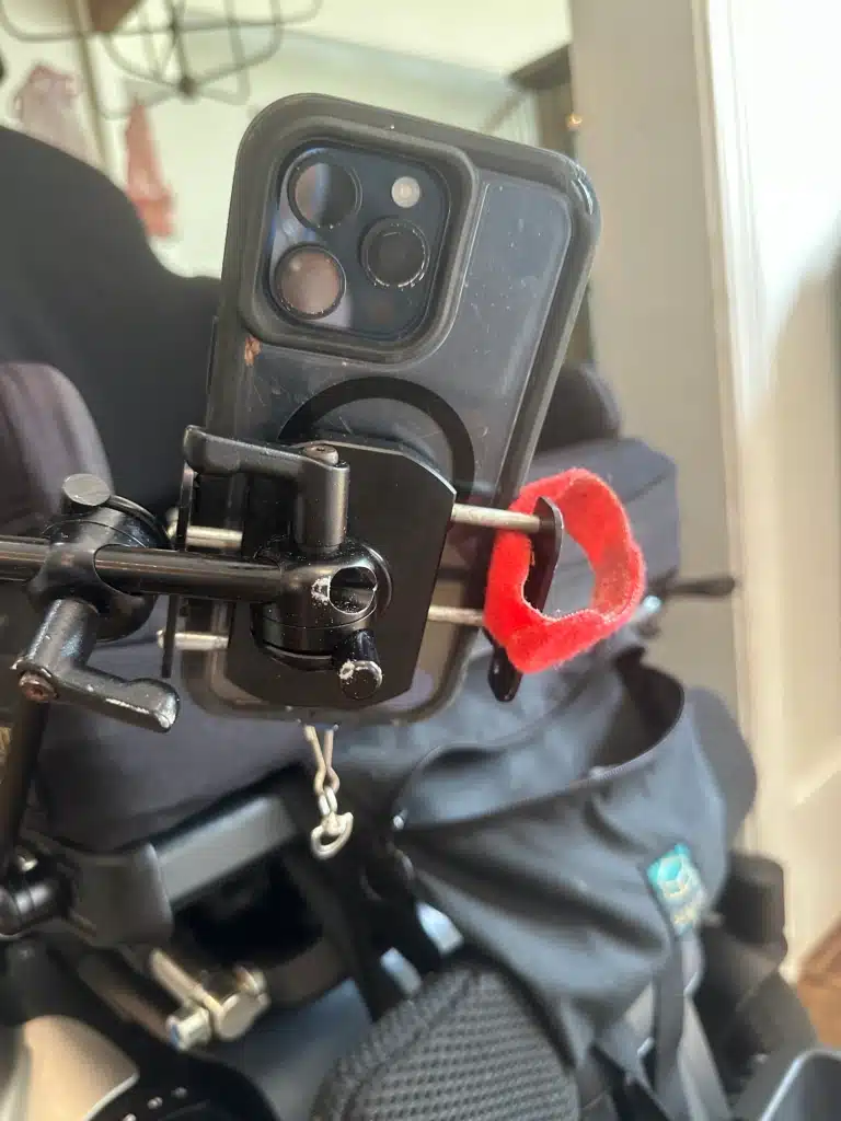 A rear view of a smartphone mounted on a wheelchair using a clamp.