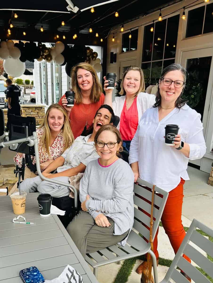 APTAT staff gathered at an outdoor café table, smiling